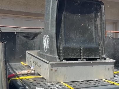 Trash bin being lifted and cleaned by the blaster